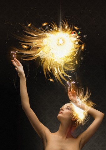 Woman reaching up to abstract glowing ball