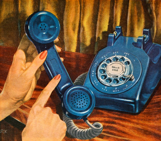 Hand holding blue rotary telephone receiver